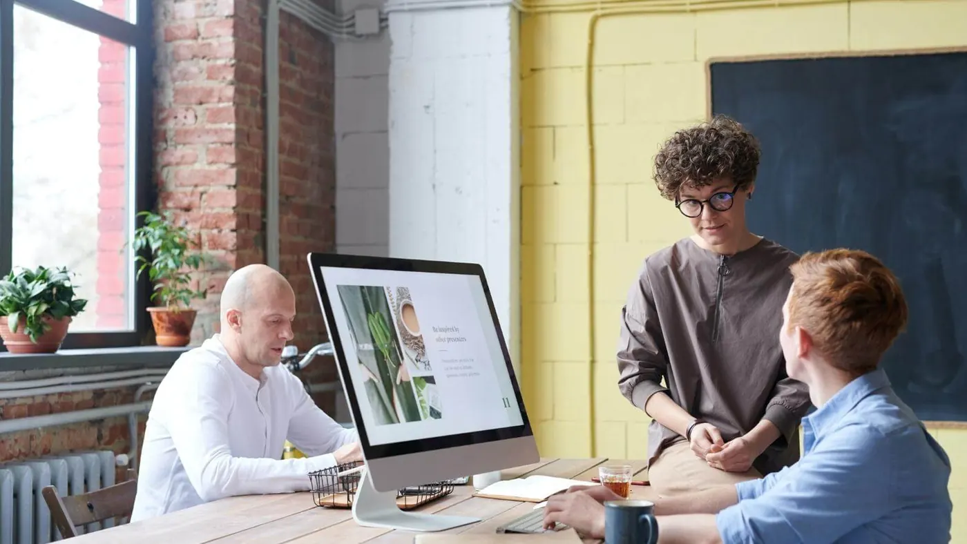 person-sitting-on-wooden-table-talking-to-colleague