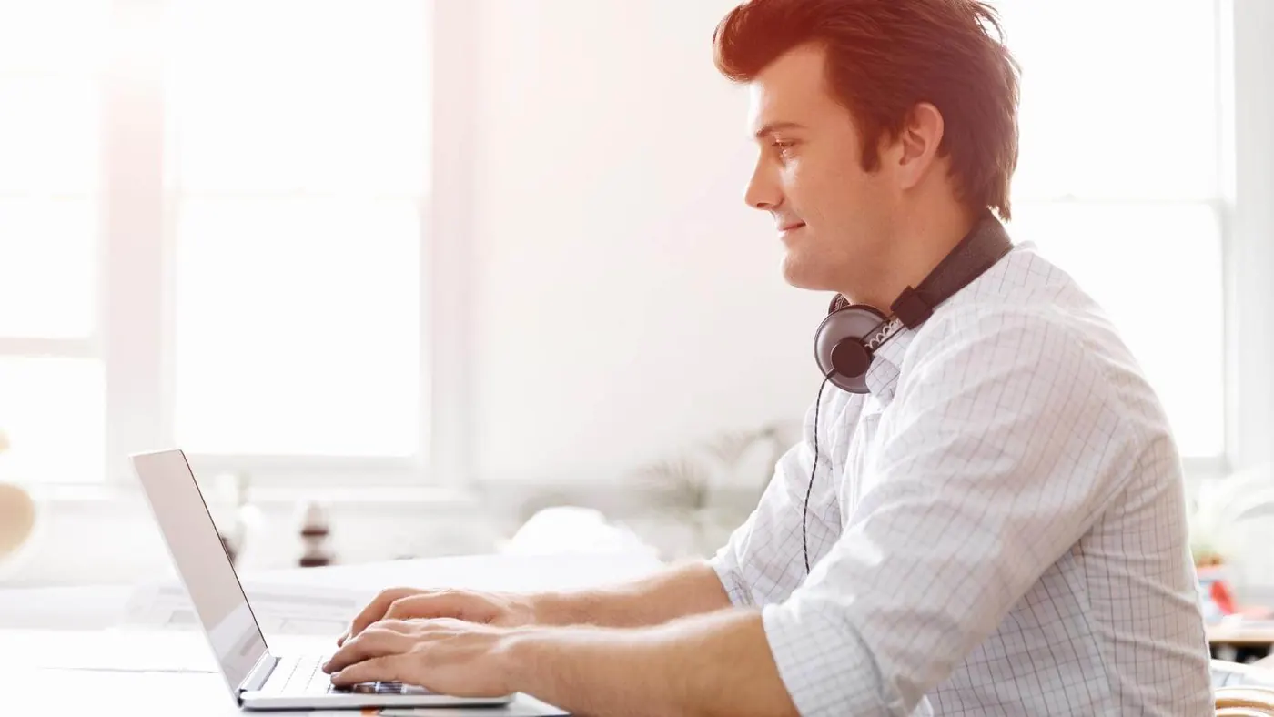 Man wearing headphones and emailing.