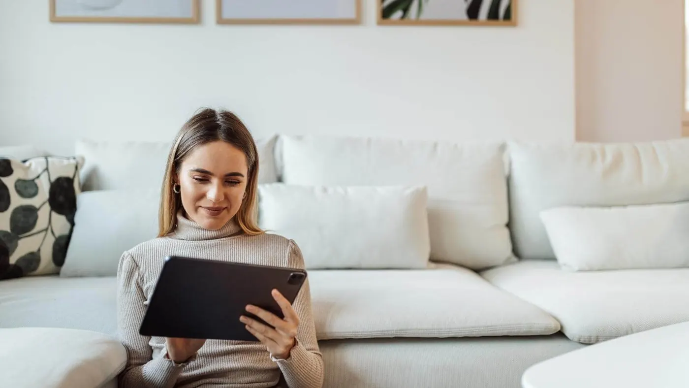 Woman sitting on floor looking at tablet