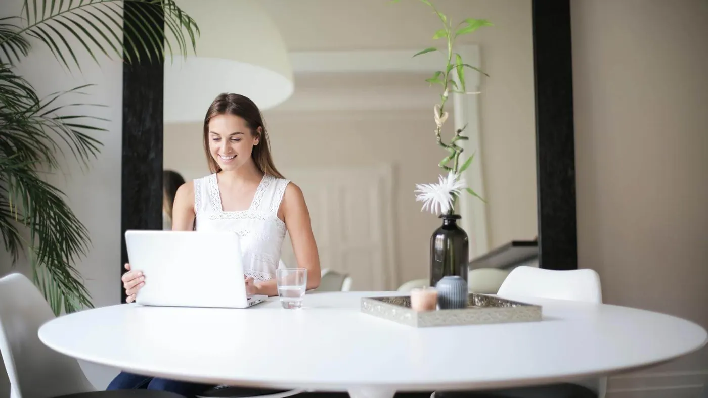 woman-sitting-on-chair-in-front-of-table-with-macbook