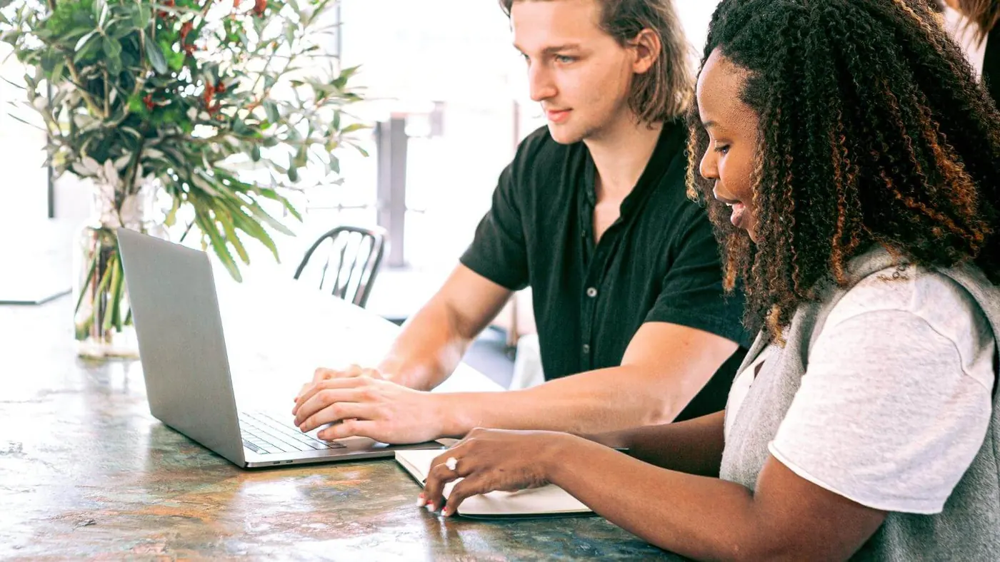 man-working-on-a-laptop-while-woman-takes-notes
