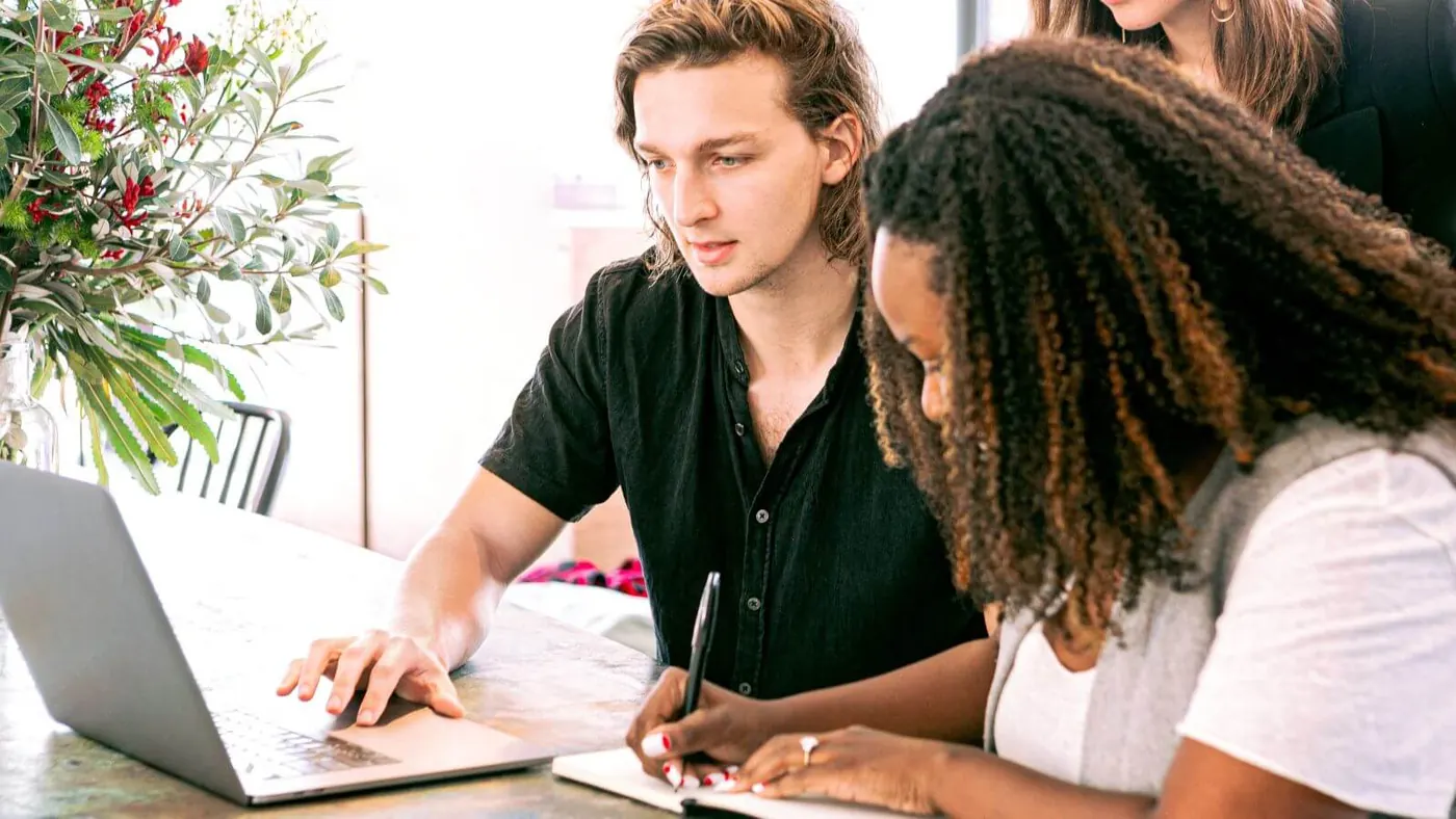 man-working-on-laptop-while-woman-takes-notes