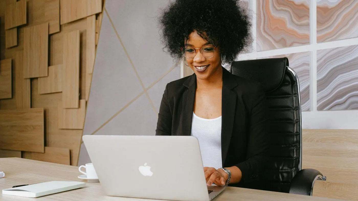 woman-in-black-blazer-sitting-by-the-table-while-using-macbook